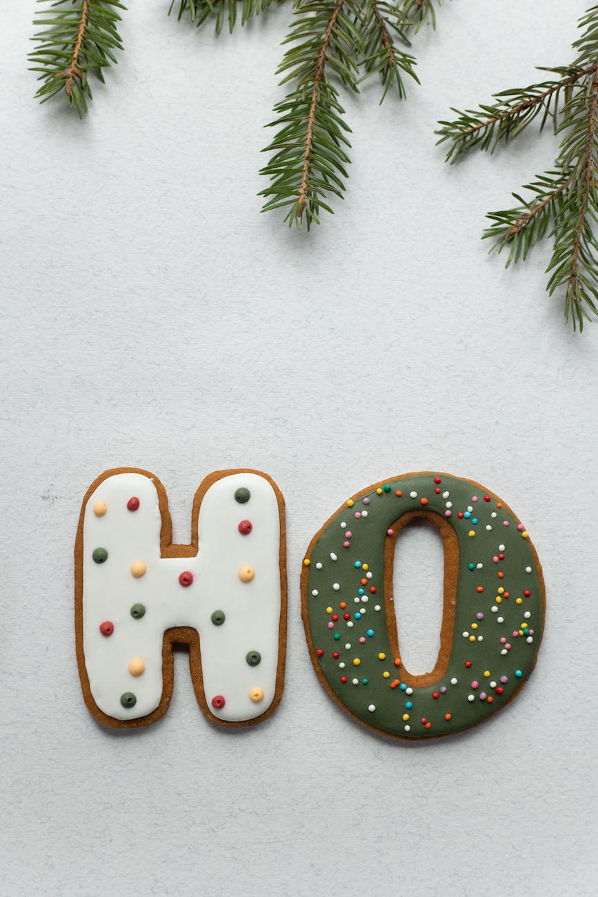 delicious gingerbread letters and christmas tree twig on white table